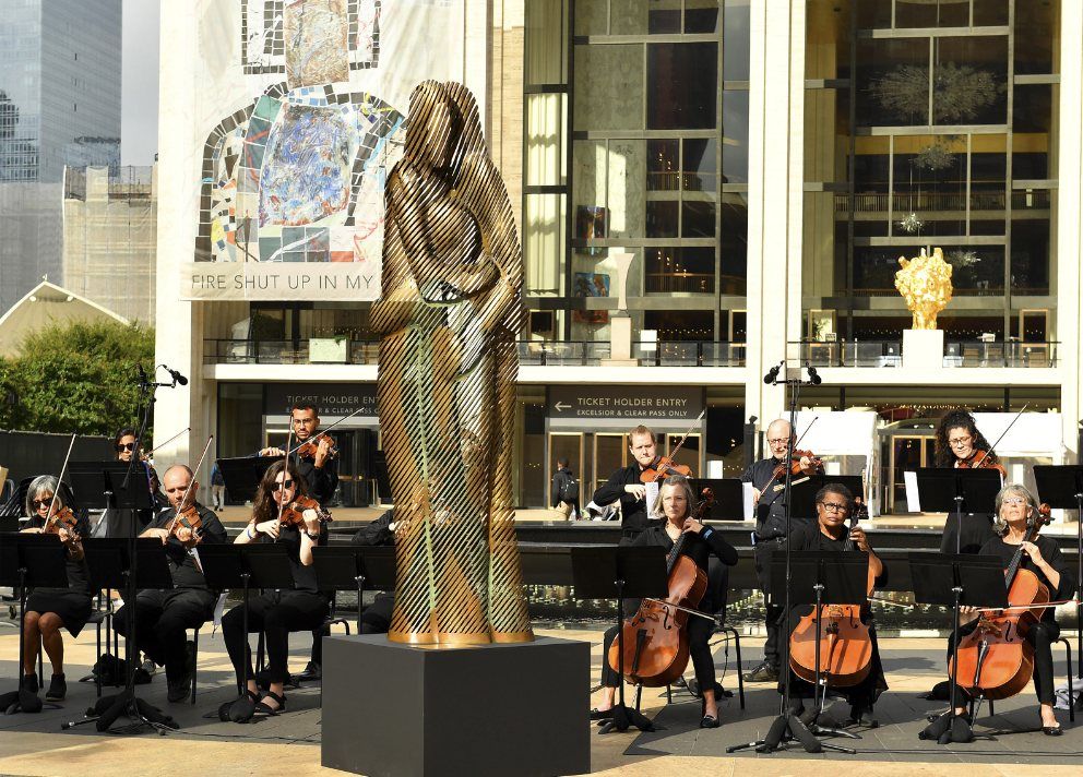 The Hug, a 10-foot bronze sculpture at Lincoln Center, with a string ensemble